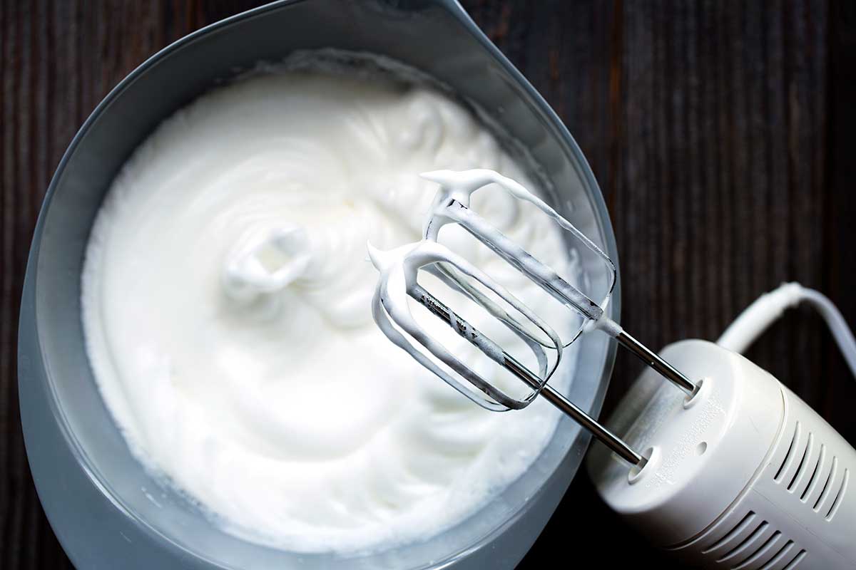 Egg whites that have been whipped to a stiff peak using an electric hand mixer.