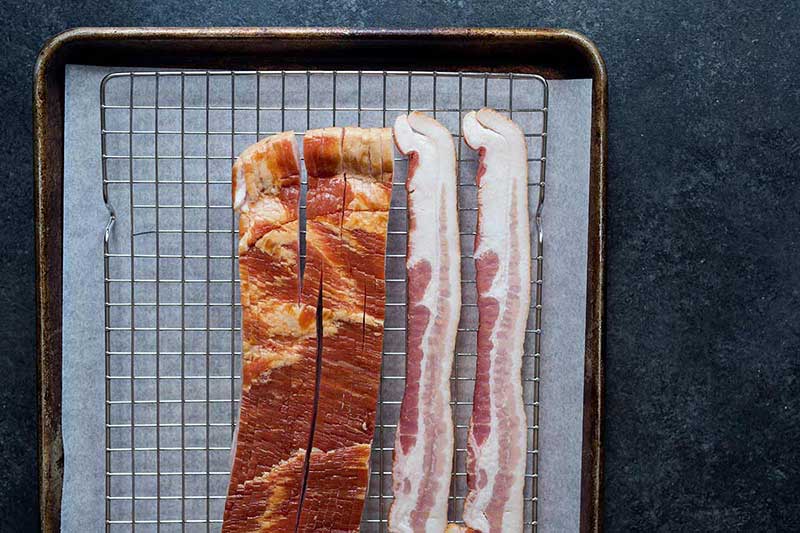 Thick-cut bacon on a sheet pan.