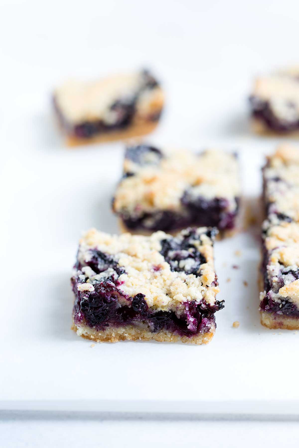 Sliced blueberry bars on a cutting board.