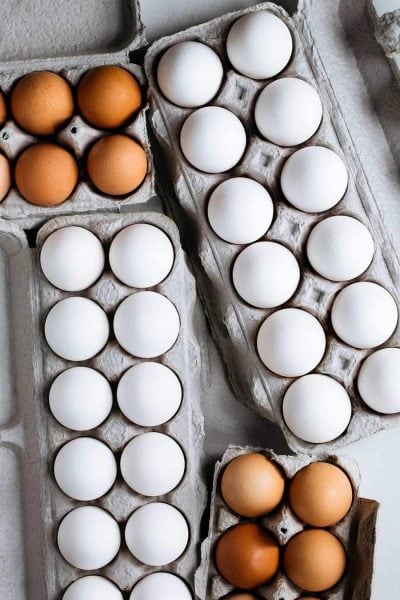 A variety of different sized and colored eggs in cartons