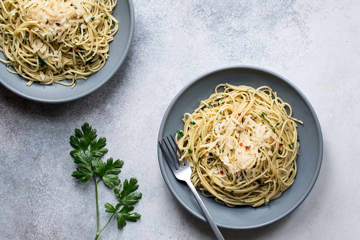 Overhead photo of anchovy pasta on a slate plate with a fork.