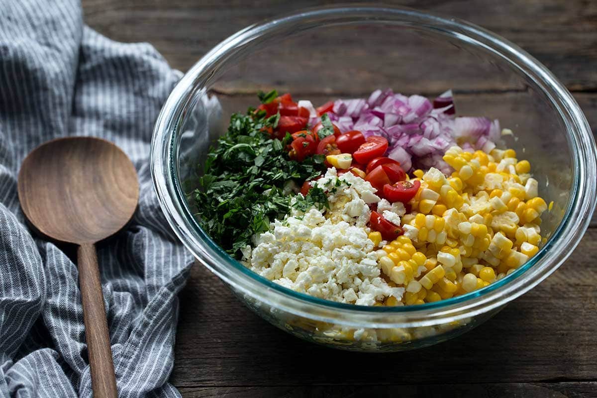 Side angle of summer corn salad ingredients in a bowl.