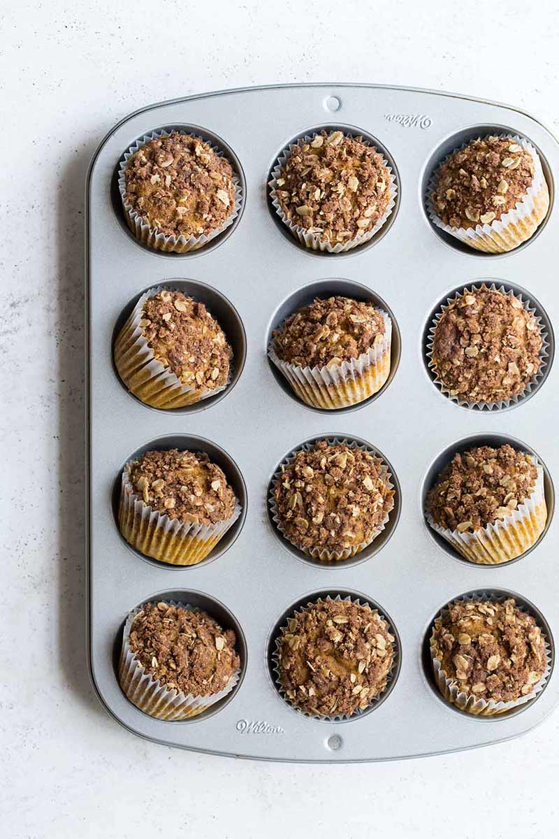 Finished pumpkin muffins shot from overhead in a muffin tin.