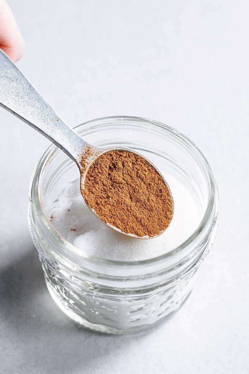 Mixing cinnamon and sugar in a small mason jar