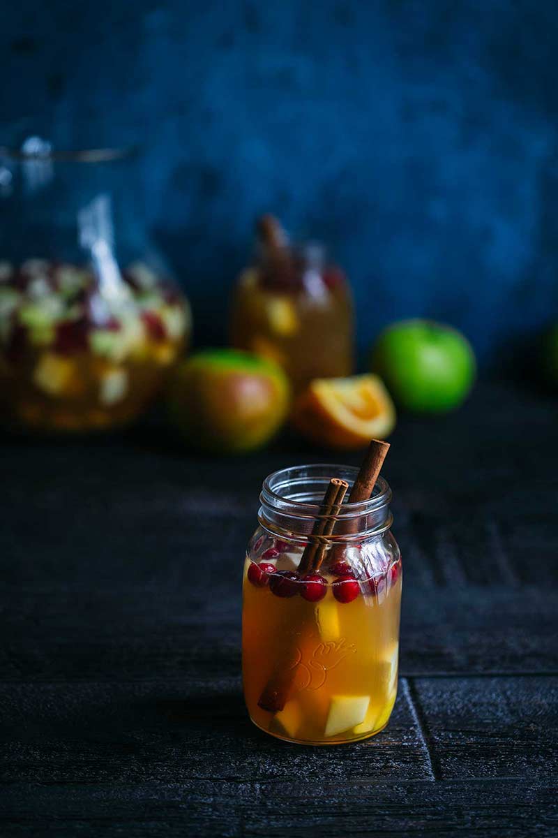 Homemade apple cider sangria in a mason jar, garnished with cinnamon sticks