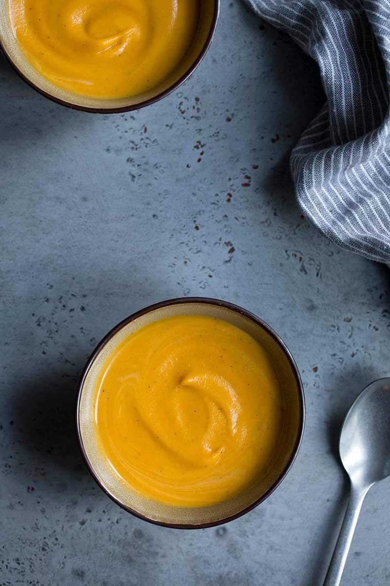 Overhead shot of two bowls of sweet potato soup.