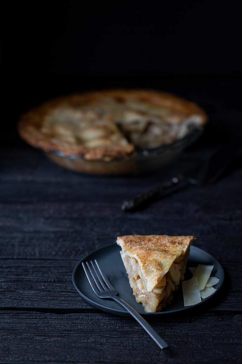 Classic Homemade Apple Pie Recipe A slice of Classic Homemade Apple Pie on a plate, with the full apple pie recipe in the background