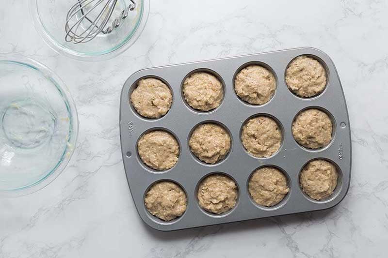Filling banana muffin batter about 2/3 full in pan