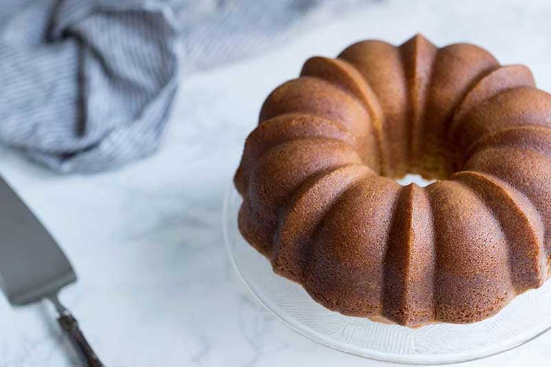 A photo showcasing a whole rum cake from scratch.