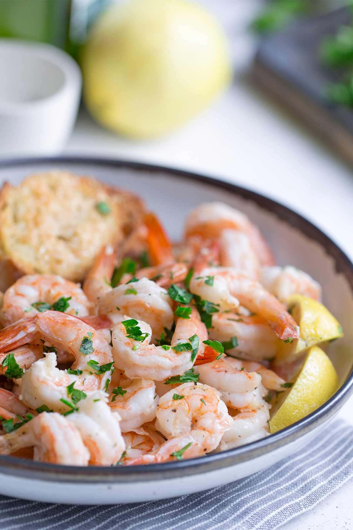 Sheet pan shrimp scampi in a bowl with bread and lemon, one of my favorite easy dinner recipes