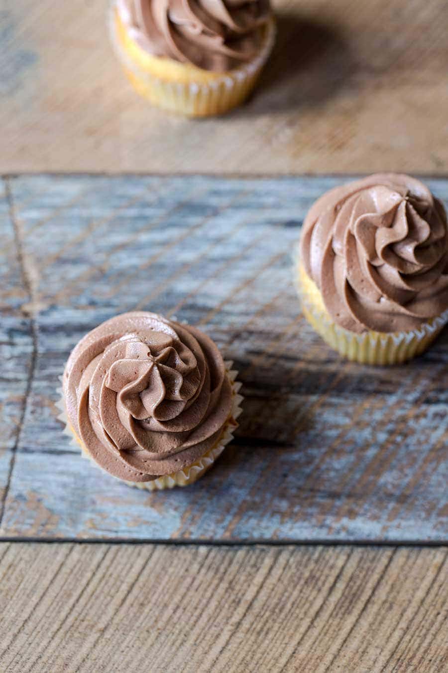 Overhead shot of vanilla cupcakes with chocolate buttercream