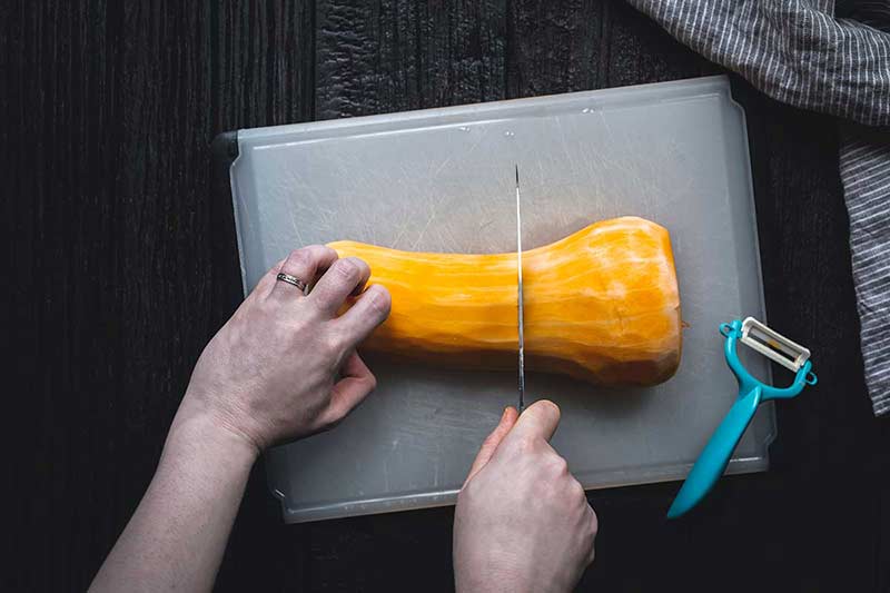 using a knife to slice one half down the center crosswise