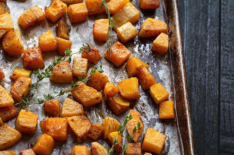 Roasted butternut squash on a sheet pan topped with thyme