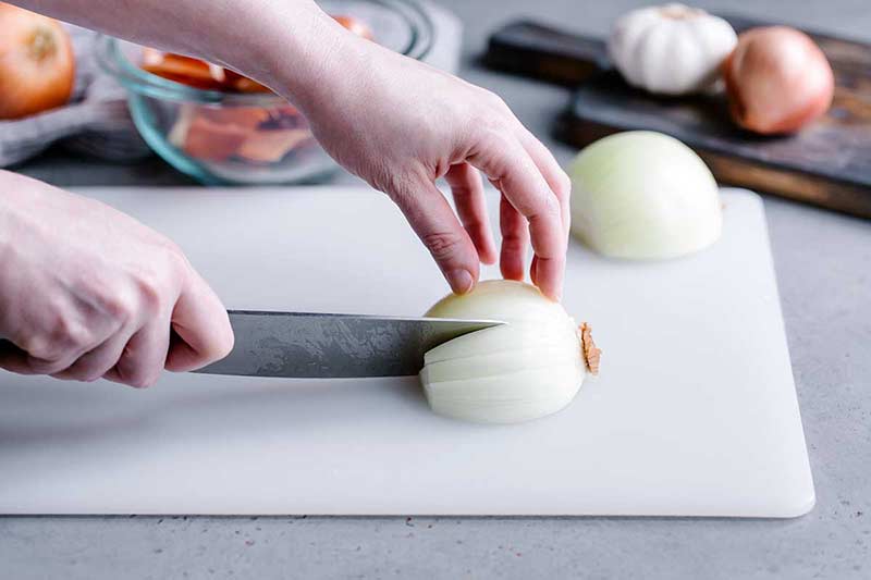 Making several slices in the onion from root to tip
