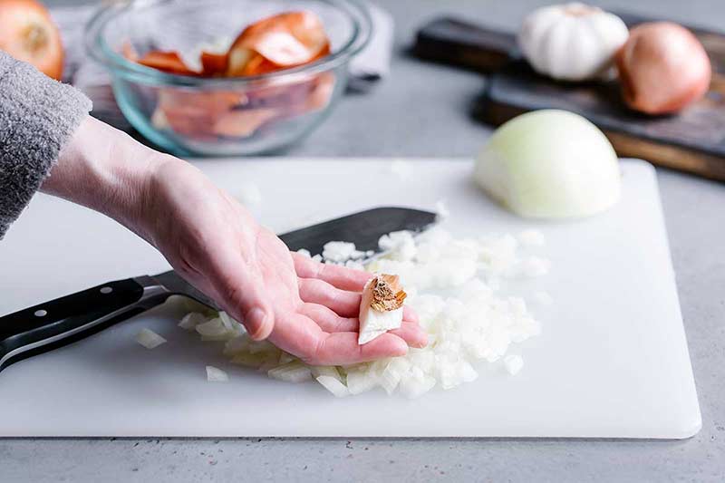 Holding the root end over chopped onions
