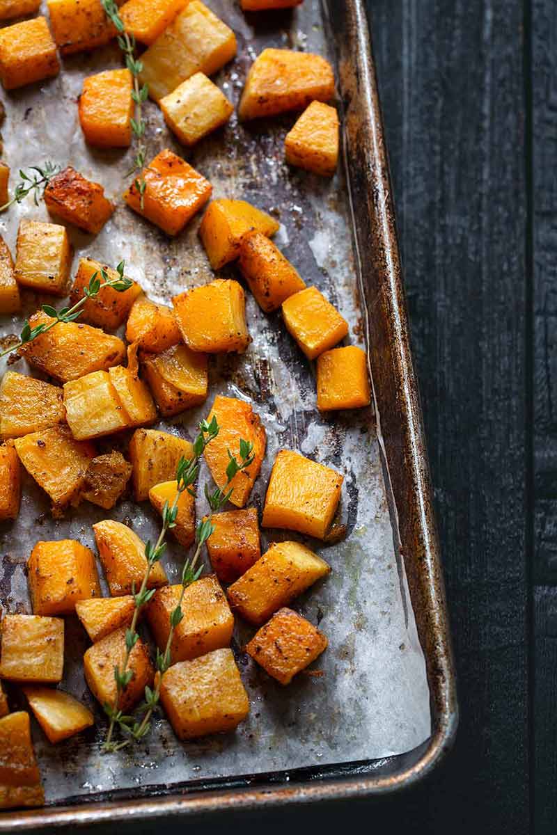 Roasted butternut squash on a sheet pan topped with thyme