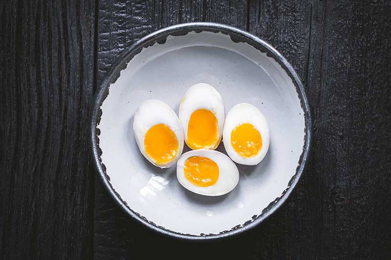 ramen eggs sliced in half on a plate