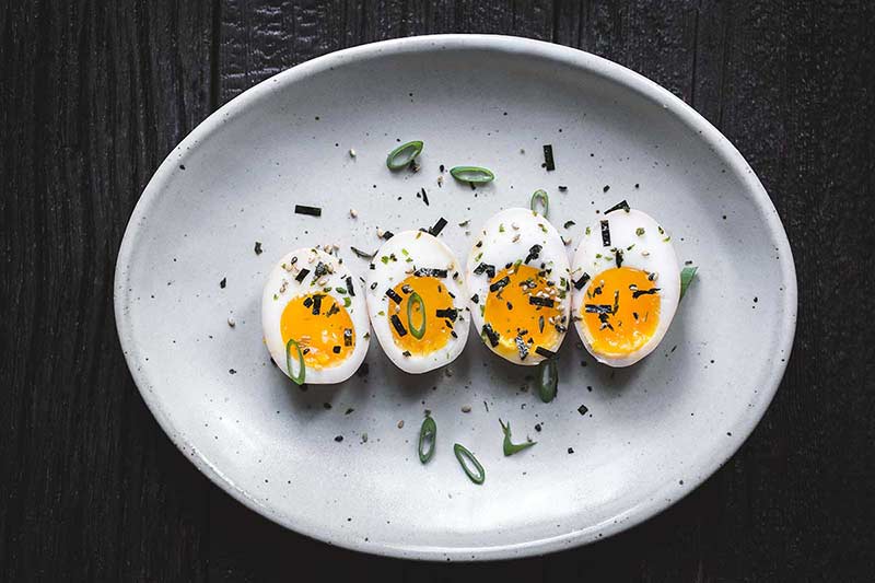 Ramen eggs garnished with scallions and furikake