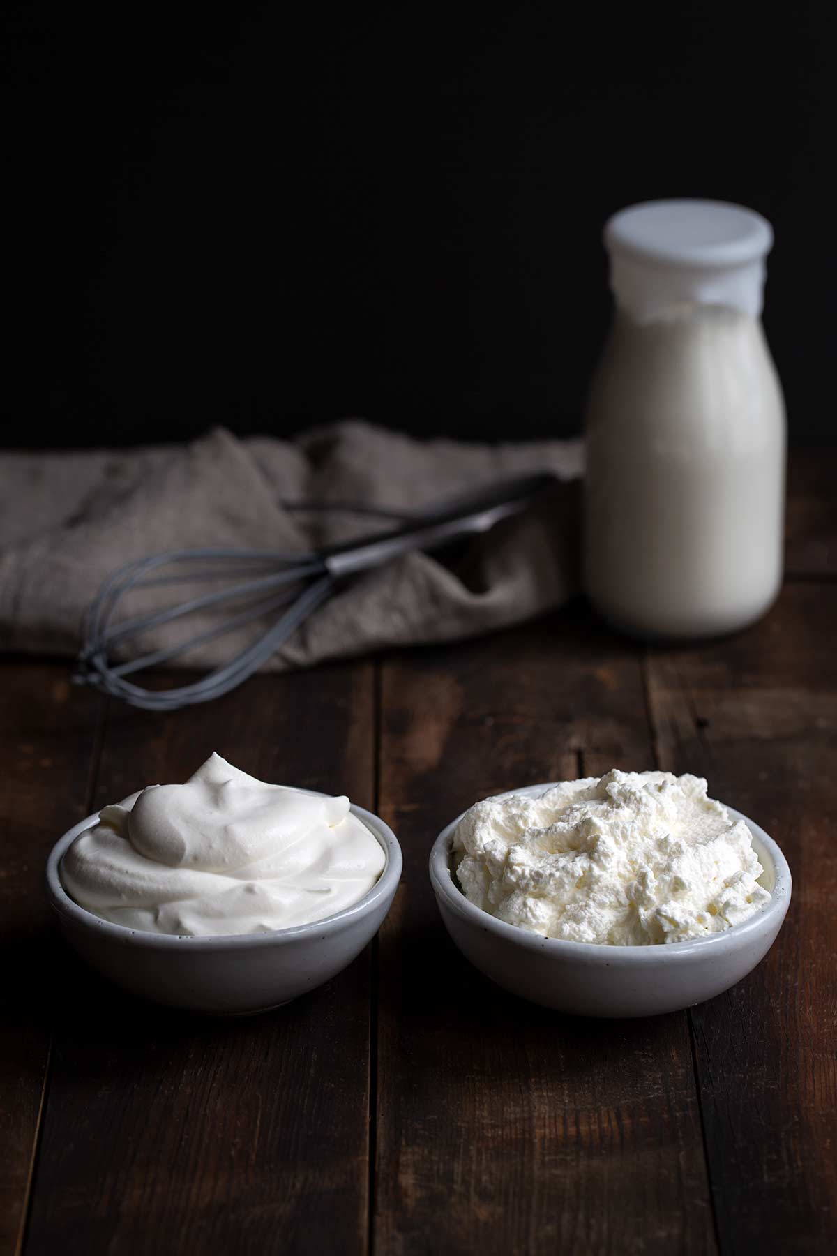 Side by side bowls of perfect whipped cream and over-whipped cream