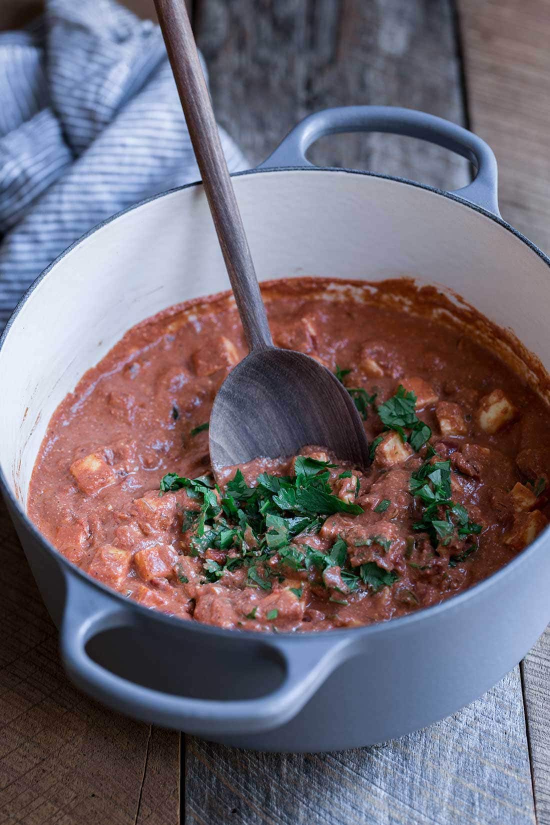 Paneer tikka masala in a dutch oven with cilantro 