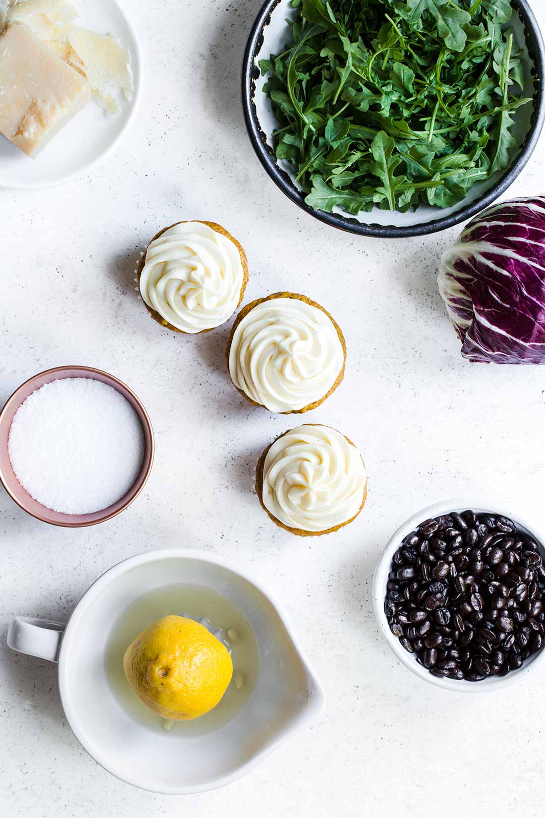 Foods representing the five tastes, including arugula, coffee beans, cupcakes, salt and parmesan.