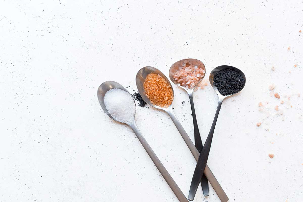 A variety of salts presented in spoons, representing one of the five tastes