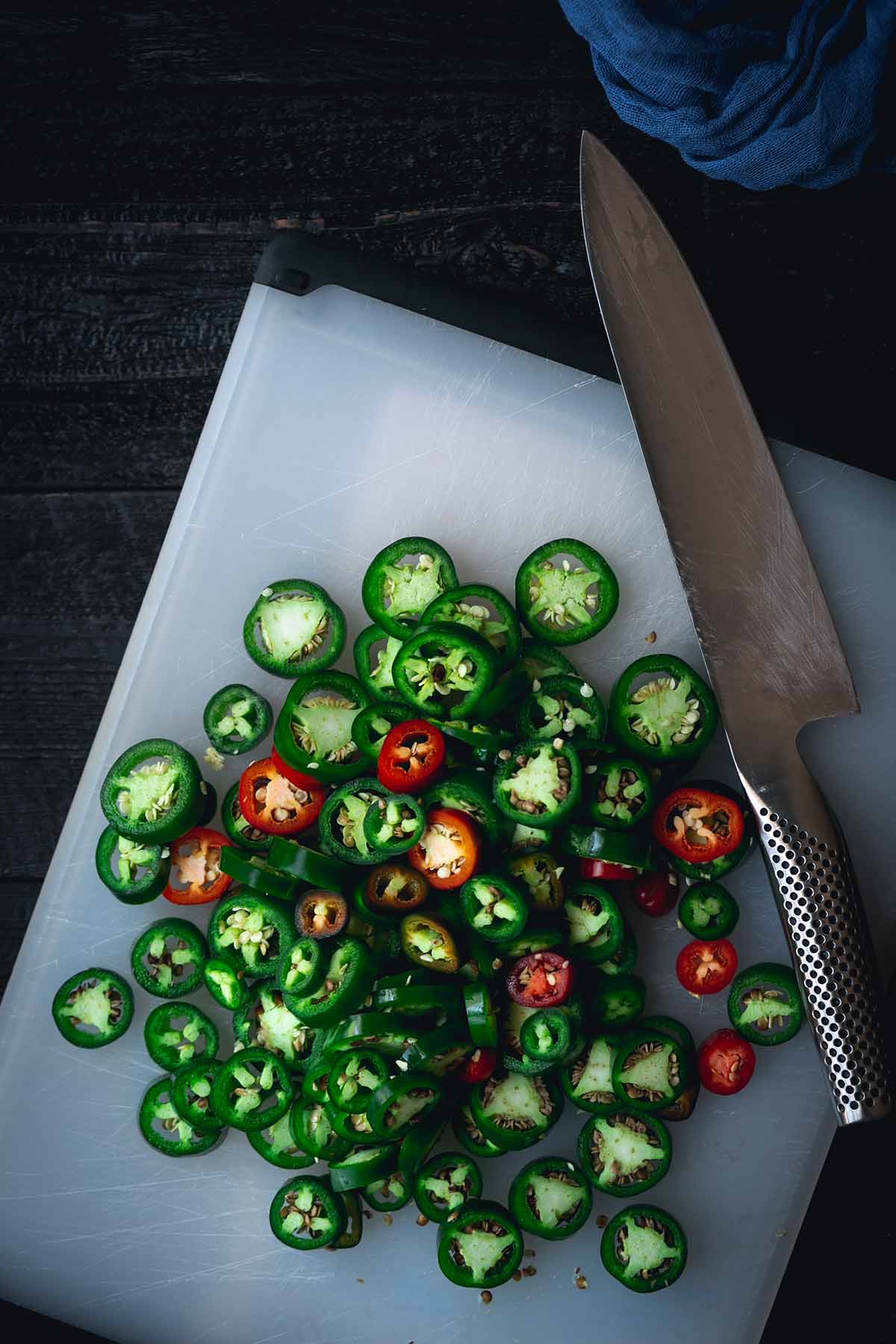 Sliced jalapenos on a cutting board
