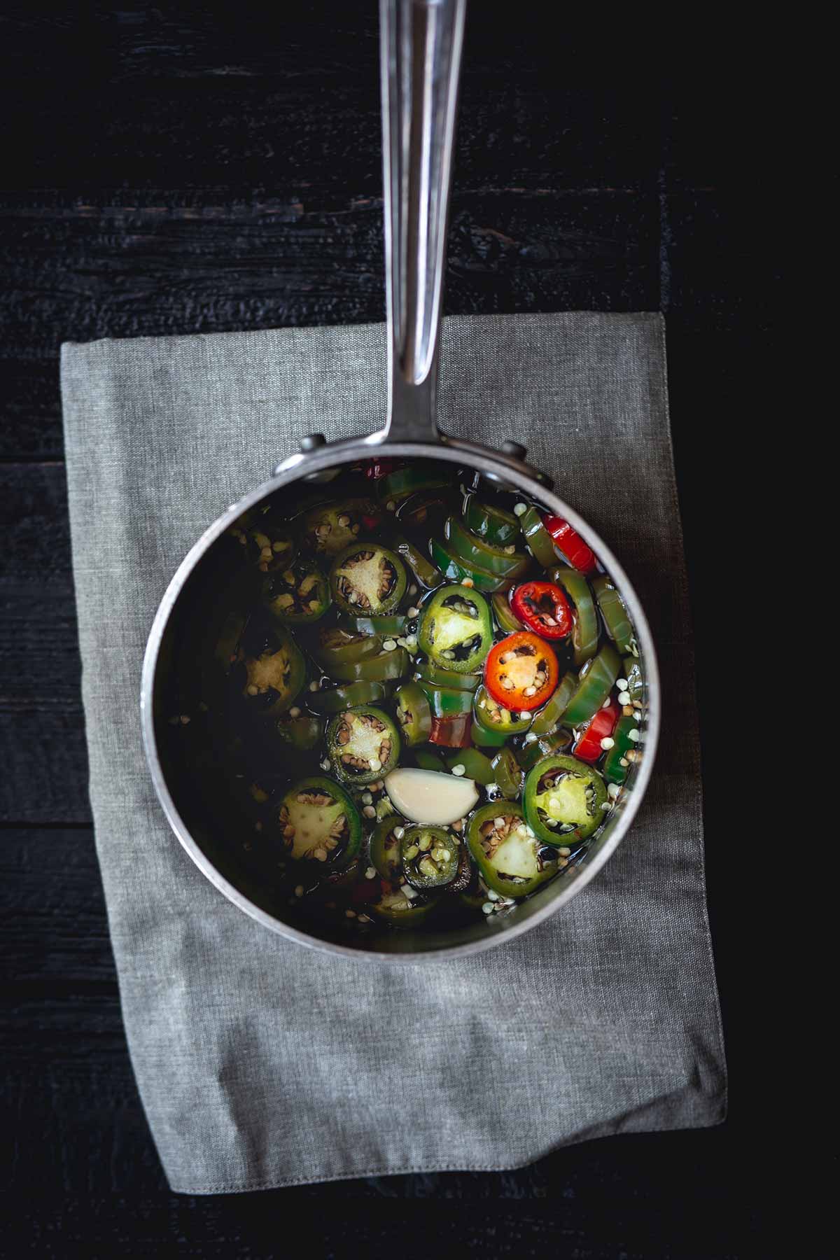 Finished pickled jalapeños in saucepan
