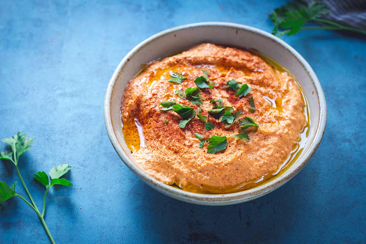 Roasted Red Pepper Hummus with parsley to the left