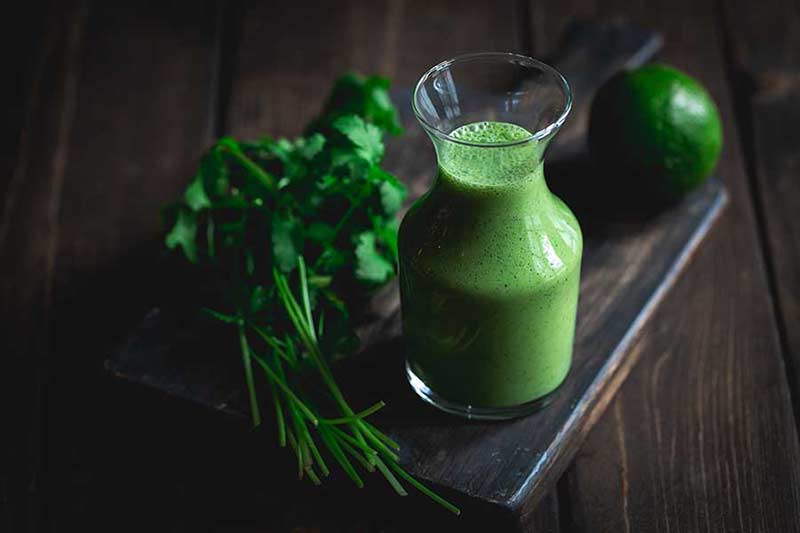 Cilantro lime dressing recipe in a bottle on cutting board