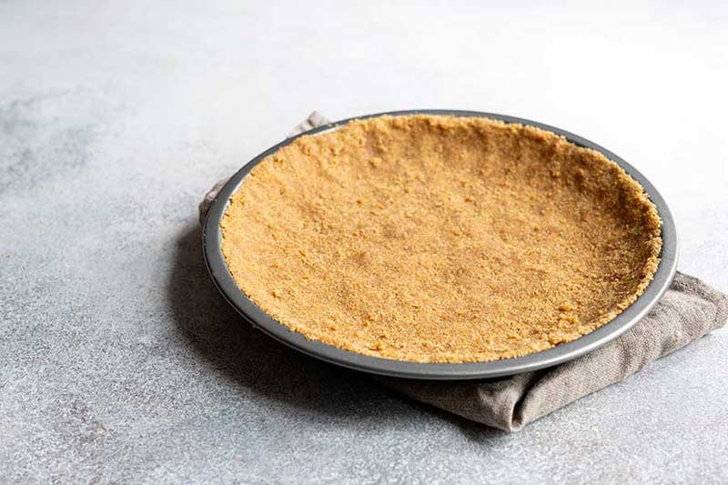 Unbaked graham cracker crust that's been pressed into a pie dish