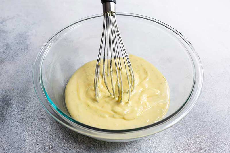 Key lime pie filling in a bowl with a whisk