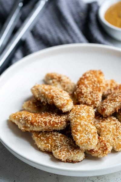 A combination of sesame seeds and panko breadcrumbs makes these chicken fingers incredibly crunchy! The peanut dipping sauce pairs perfectly.