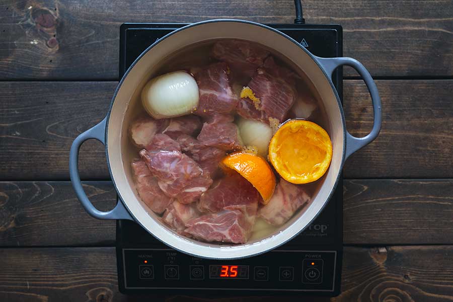 Pork, onions, orange, and other ingredients in melted lard