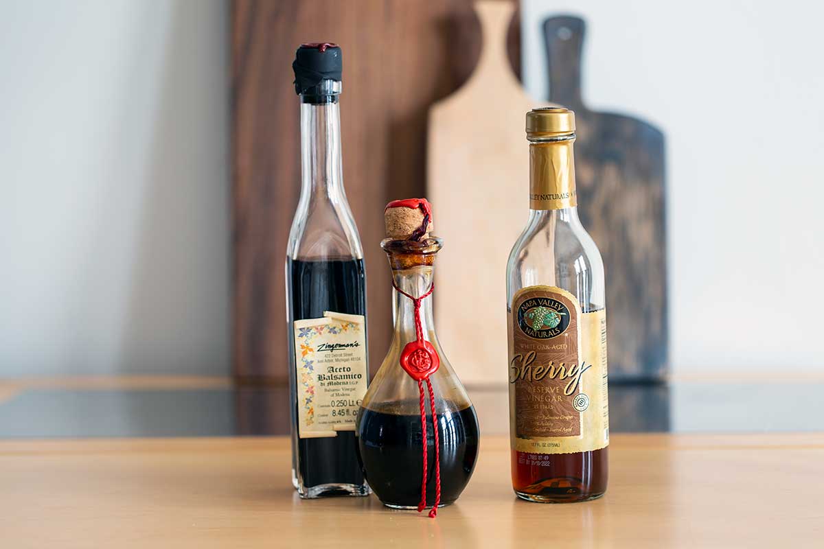 3 bottles of vinegar on a table 