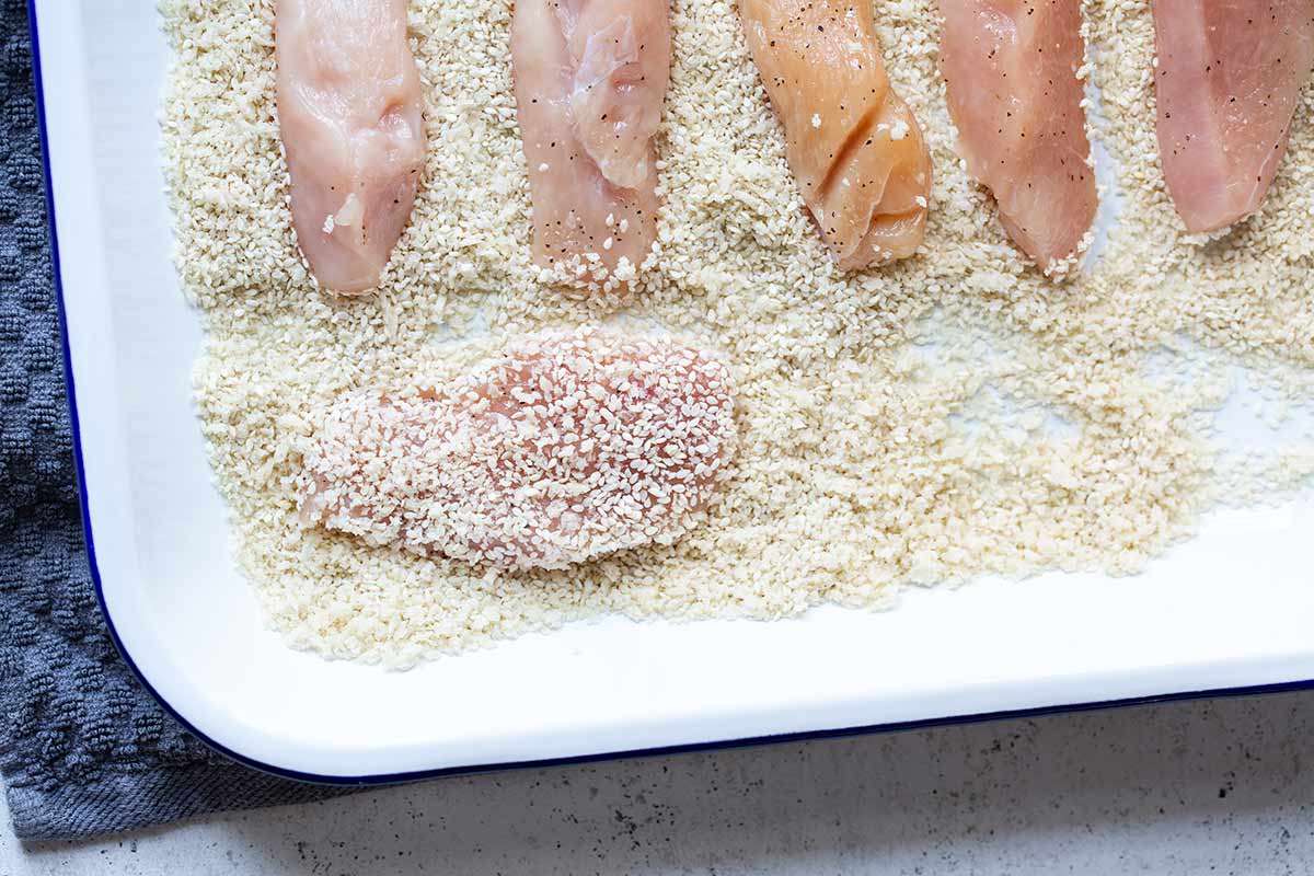dredging chicken in sesame seeds and panko