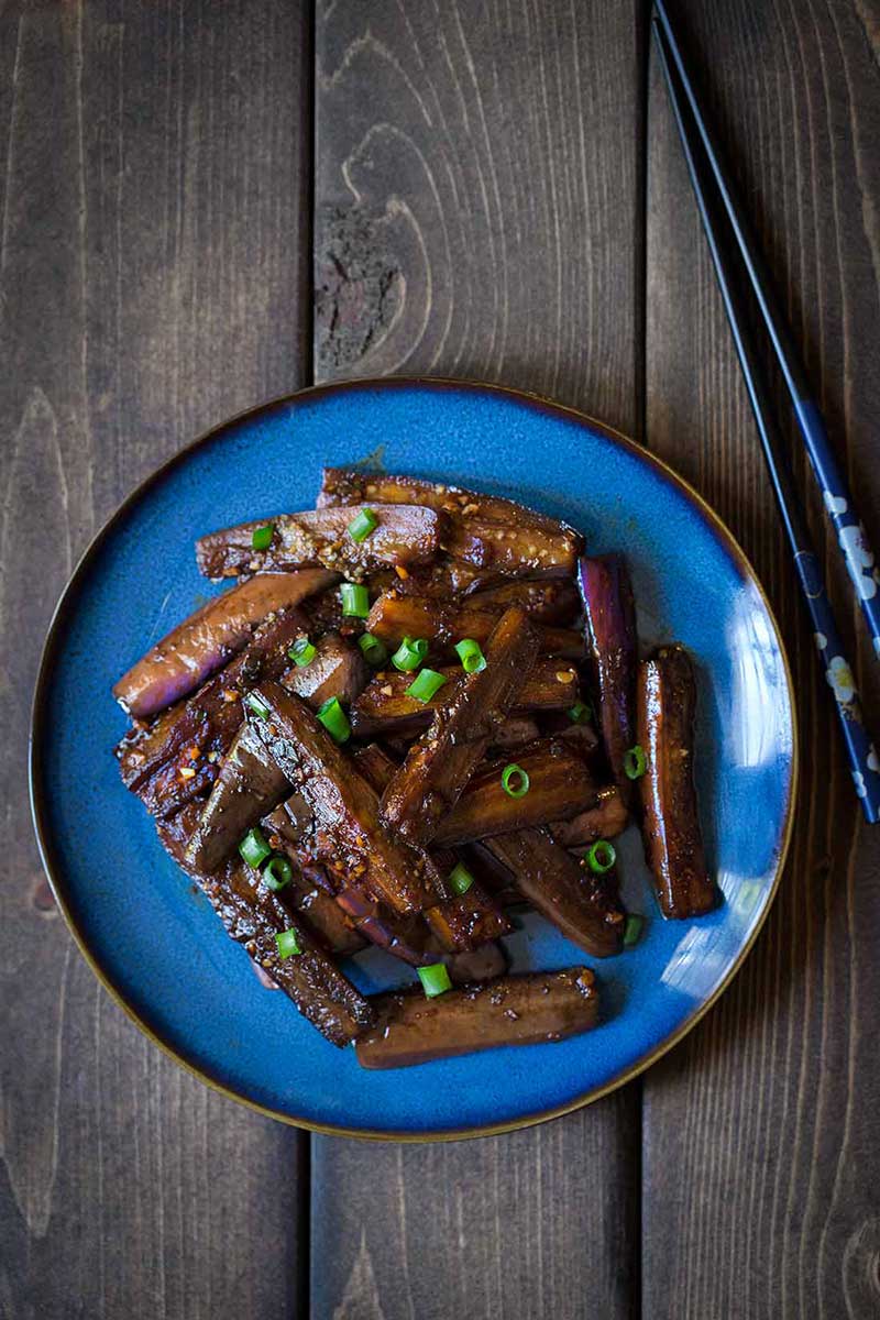 Chinese eggplant recipe on a blue dish with chopsticks