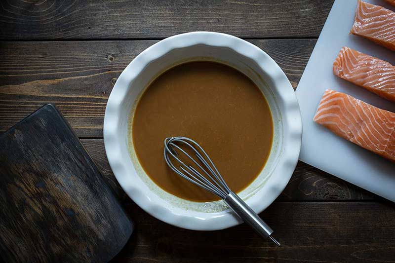 whisking the marinade ingredients in a shallow dish