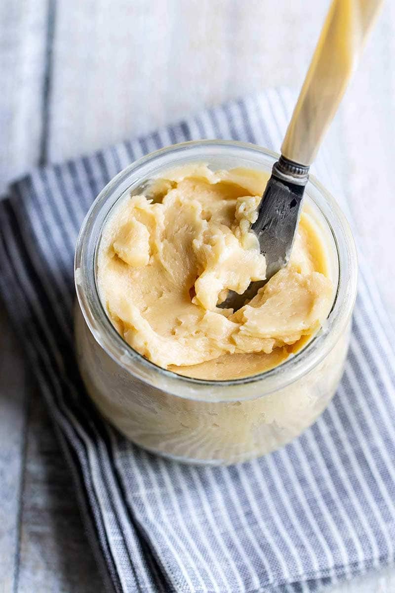 close up of whipped maple butter recipe in a mason jar with a butter knife