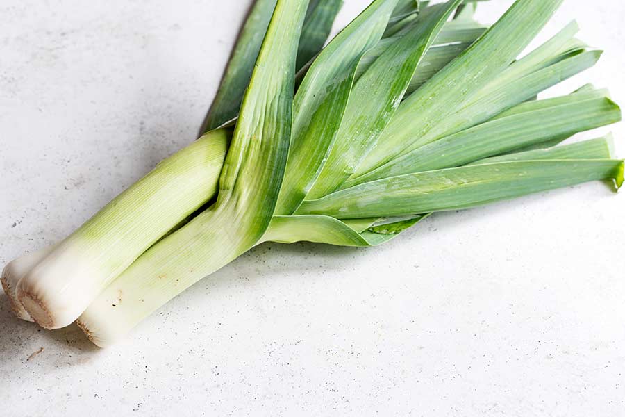 two leeks on a white backdrop