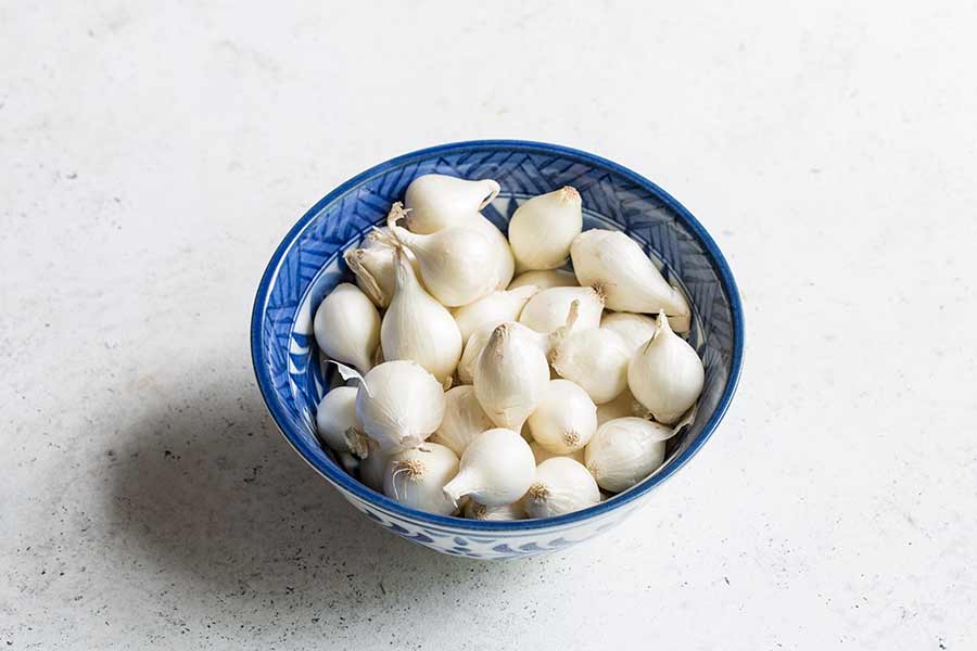 a blue bowl filled with pearl onions
