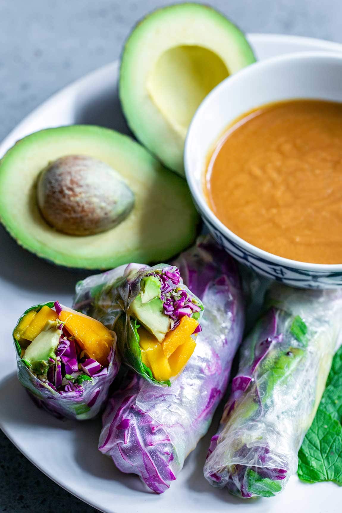 Vegetarian Summer Rolls next to peanut sauce and avocados