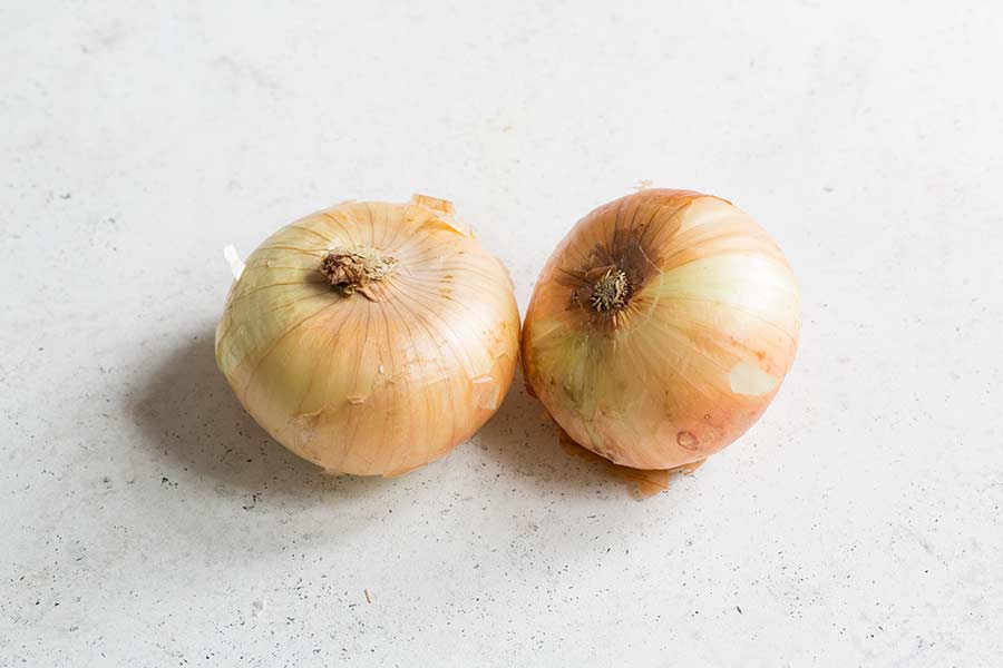 two vidalia onions on a white surface