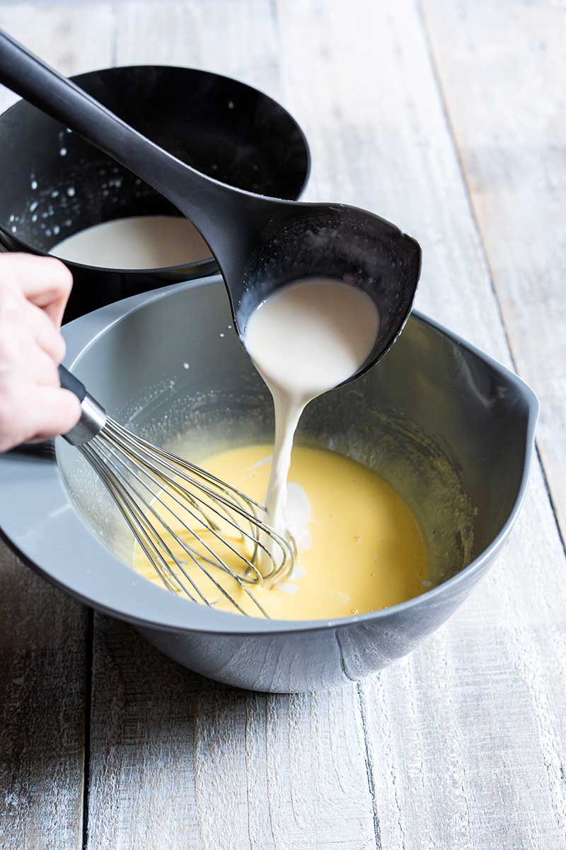 Tempering hot cream into yolk sugar mixture