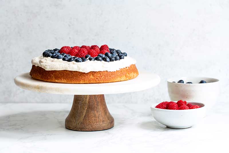 The cake topped with both raspberries and blueberries for a “red, white and blue cake” effect.