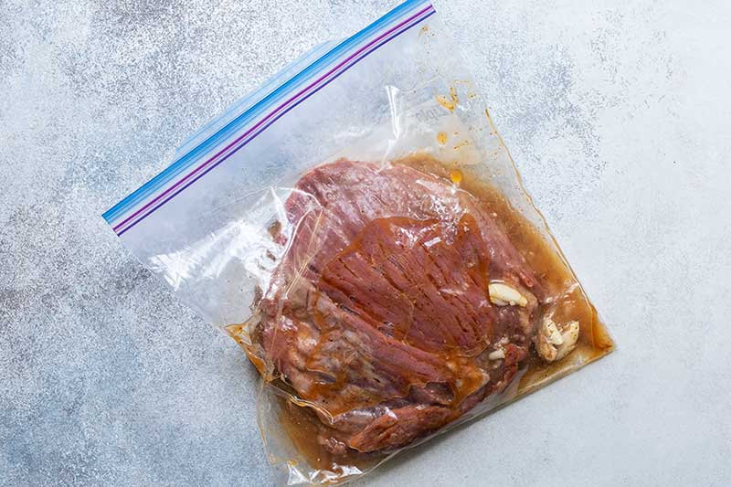 Steak taco marinade: flank steak in a plastic bag filled with marinade