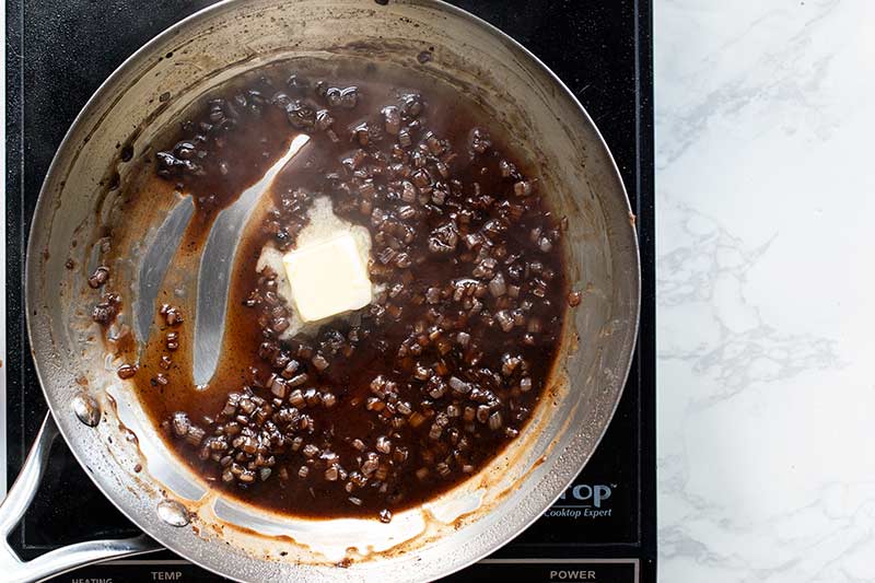 Adding a pat of butter to finish the pan sauce