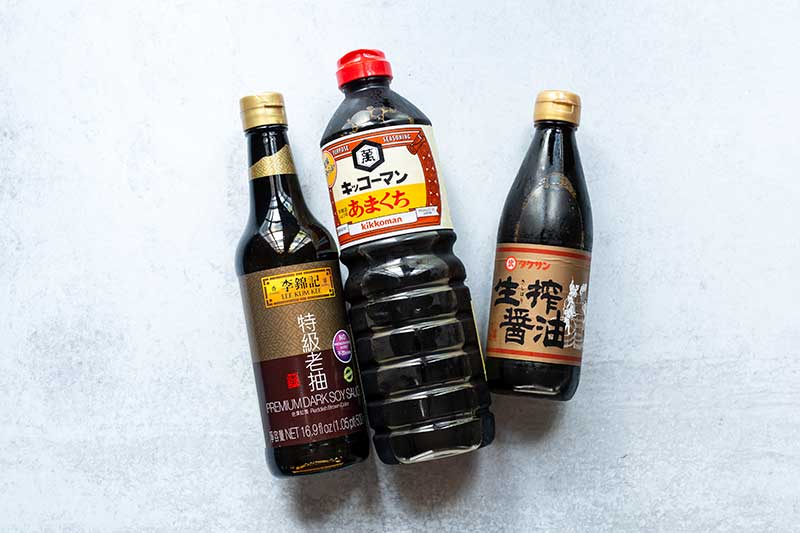 Three bottles of soy sauce laid out next to one another