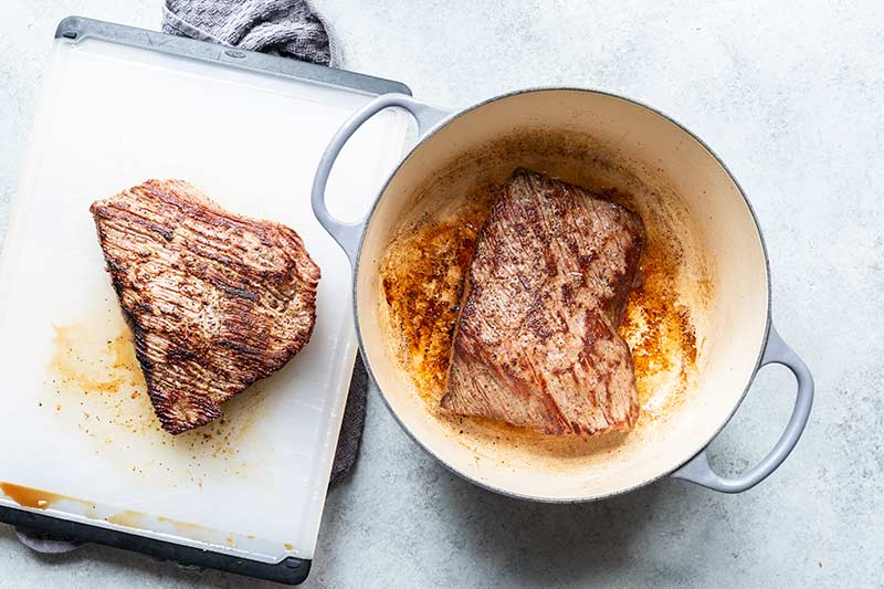 Two sections of beef roast that have been seared in a dutch oven