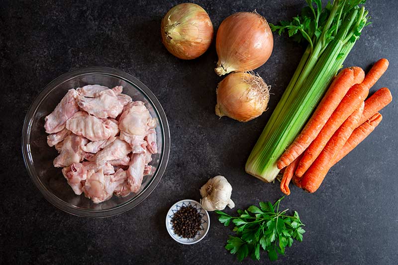 Ingredients on black background for making a chicken stock recipe